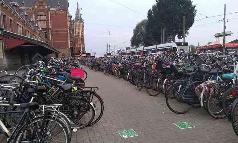 Foto de dezenas de bicicletas estacionadas em Amsterdã