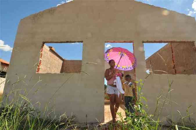 Jaqueline Rosrio da Silva com os dois filhos numa das unidades do conjunto em Quartel Geral: as casas deveriam ter sido concludas em maio 