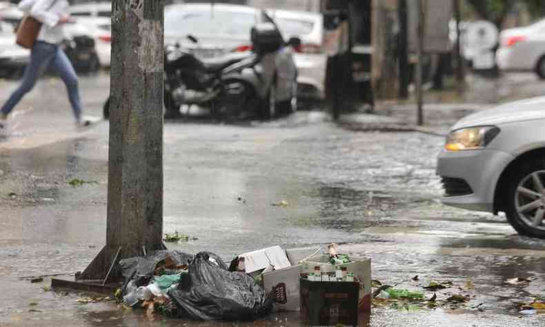 Lixo espalhando perto de uma rvore em um dia chuvoso em Belo Horizonte. 