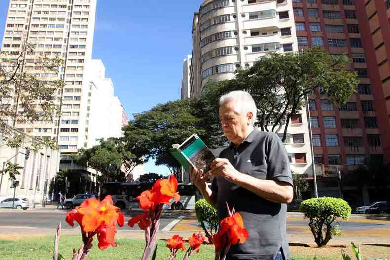Jornalista Chico Brant l o livro Barro Preto na Praa Raul Soares, em BH. No primeiro plano veem-se flores vermelhas