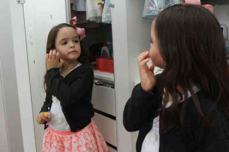 Mariana, de 5, no espelho: 'Pra ficar bonita'
