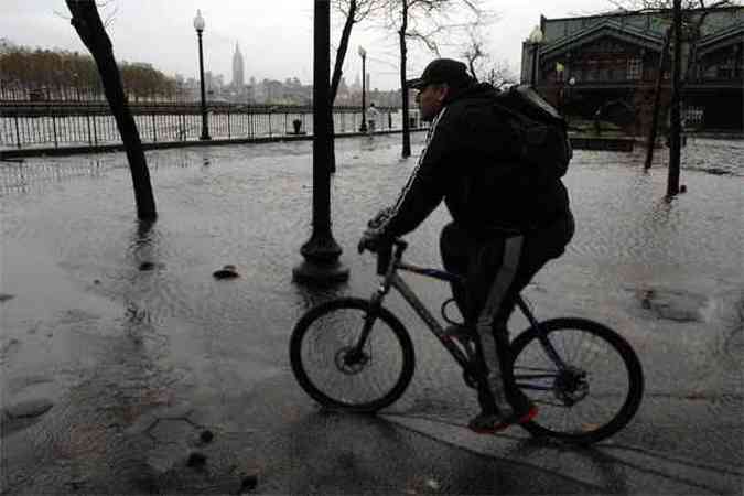 Ciclista circula por rua alagada em Nova Jersey(foto: Michael Bocchieri/Getty Images/AFP)