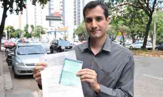 Ângelo Nogueira e documentos do veículo roubado em assalto, que custou ainda celulares e laptop(foto: Jair Amaral/EM/DA Press)