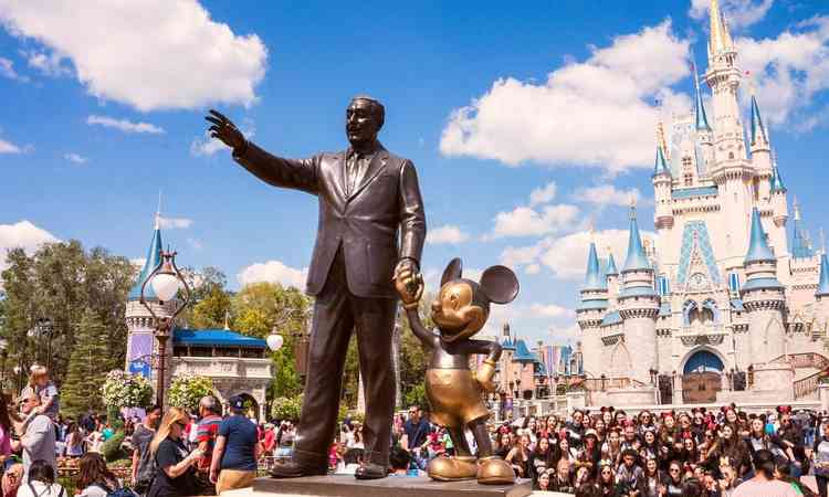 Esttua do Walt Disney de mos dadas com o Mickey em frente ao castelo da Cinderela