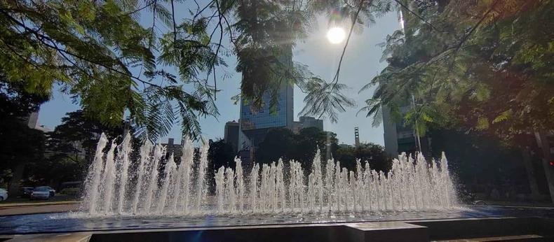 Dia é de céu claro e temperaturas amenas em Belo Horizonte(foto: Jair Amaral/EM/D.A Press) Fonte da Praça da Savassi, com árvores ao redor, prédio ao fundo e sol