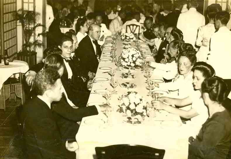 Pessoas sentadas em enorme mesa durante jantar de gala no Automvel Clube, em BH
