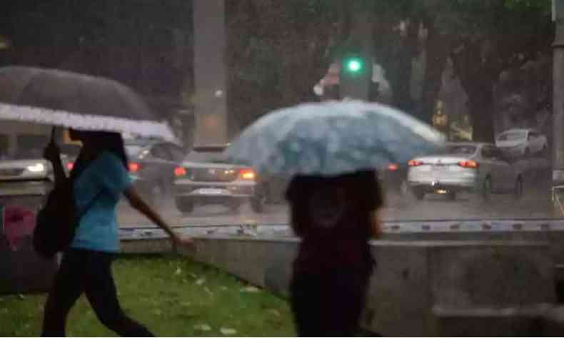 Pessoas andando nas ruas com guarda-chuvas