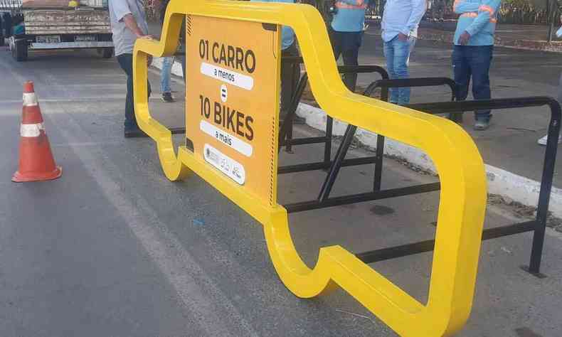 Estrutura amarela em formato de um carro com vagas para bicicletas