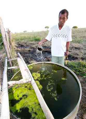 O agricultor Jos Mendes e a gua escura extrada de um dos poos(foto: Fotos: Solon Queiroz/especial para o EM )