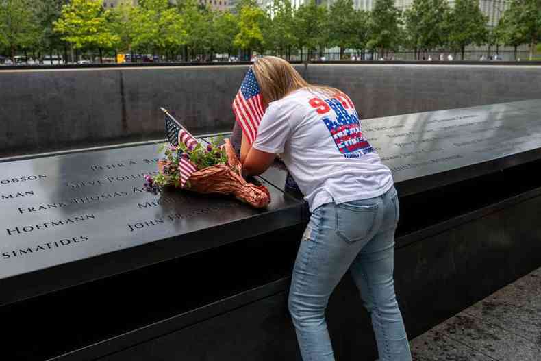 Mulher cobre o rosto, emocionada, em dia de homenagem s vtimas do 11/9