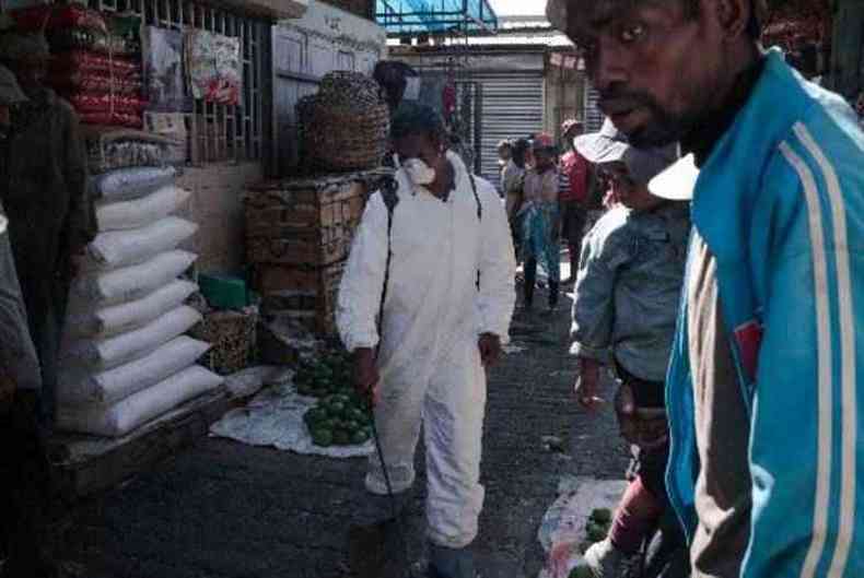 Funcionrio dos rgos de sade desinfeta corredores de mercado em Antananarivo (foto: RIJASOLO/AFP)