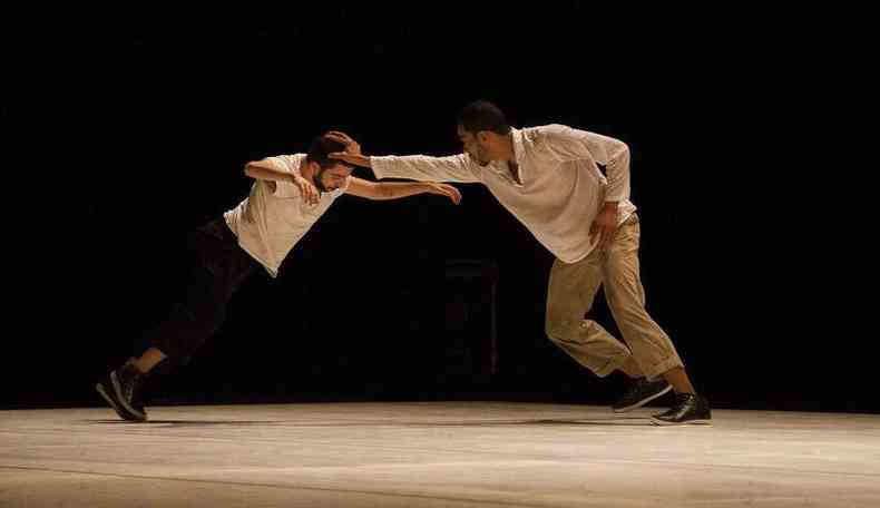 Dois homens se enfrentam mimetizando uma luta na coreografia Divinéia