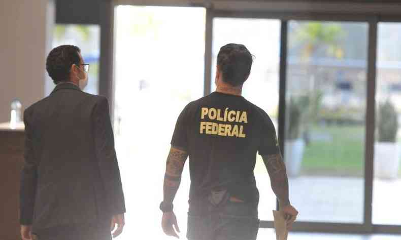 Agente Federal espera avião com brasileiros deportados dos Estados Unidos