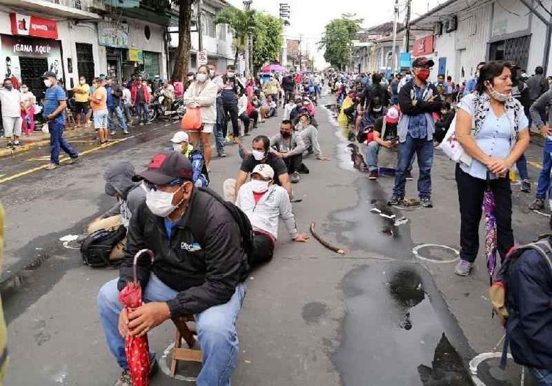 Pessoas fazem fila do lado de fora de um banco para receber aux�lio do governo na cidade de Iquitos(foto: Getty Images)