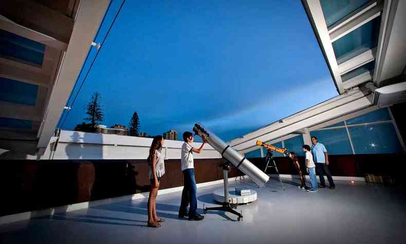 Visitantes observam telescópios no planetário do Espaço do Conhecimento