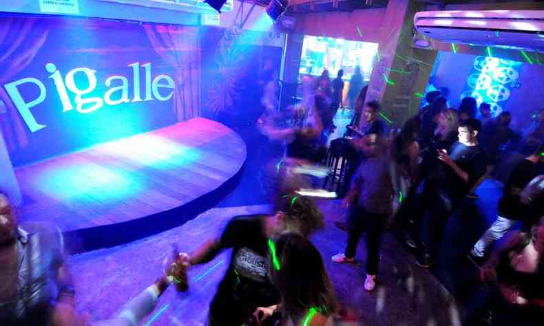 Interior do bar de Pico Pigalle, com pista animada, luzes coloridas e casal se beijando 