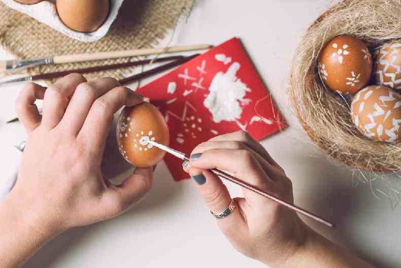 Mulher pintando casca do ovo