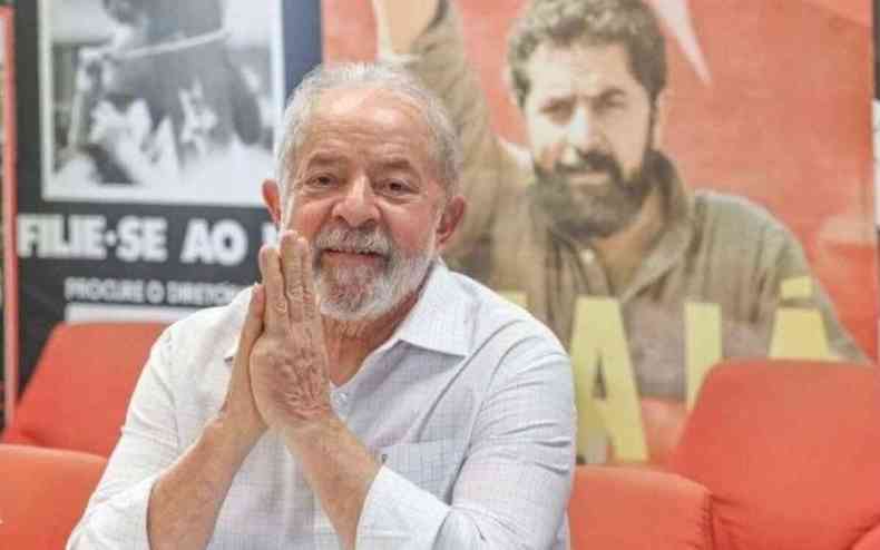Lula posa para fotos em frente a cartazes do PT