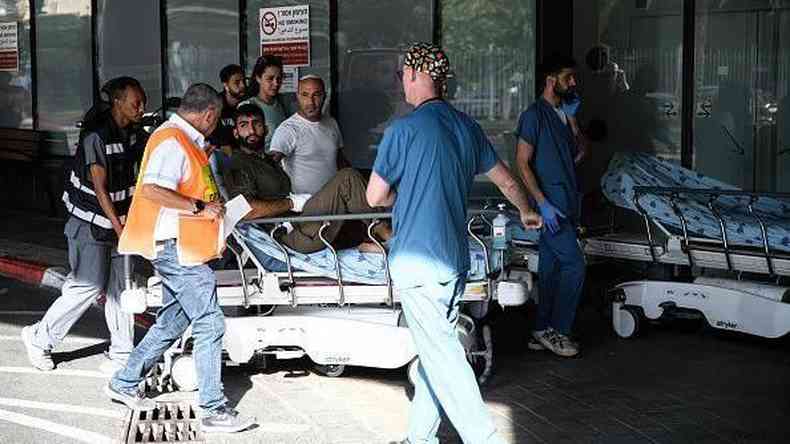 Mdicos empurram um homem ferido na entrada de emergncia do hospital Ichilov, em Tel Aviv, aps uma incurso do Hamas nos assentamentos israelenses ao redor da Faixa de Gaza