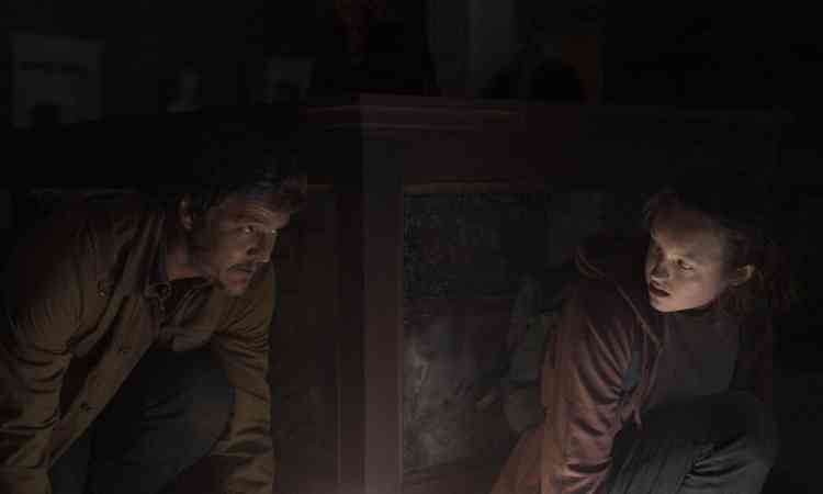 Os personagens Joel Miller (Pedro Pascal) e Ellie (Bella Ramsey),  lado a lado, em cena de 'the last of us'
