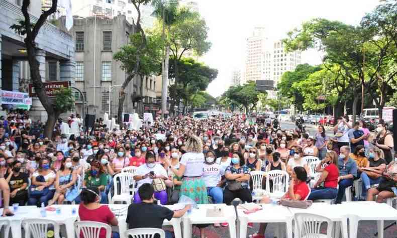 Centenas de funcionrios da rede municipal de ensino sentados em cadeiras plsticas em frente  Prefeitura de Belo Horizonte