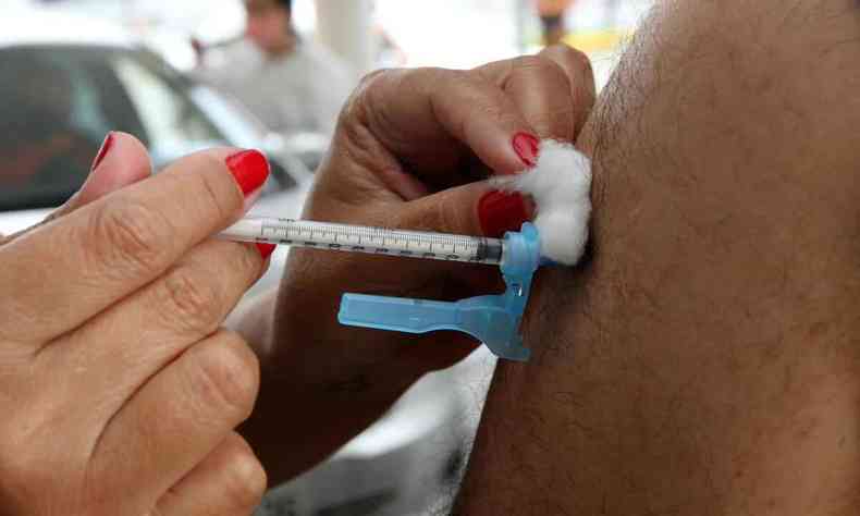Vacina contra a COVID-19 sendo aplicada em um brao
