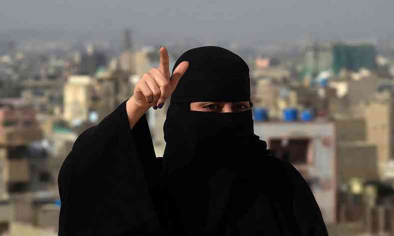 Usando hijab preto, a rapper Eva B posa para foto no telhado de um edifcio em Karachi