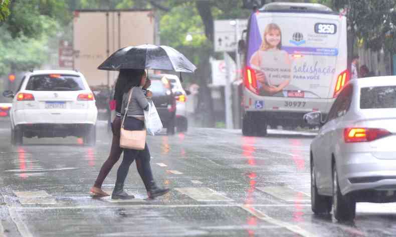 Imagem de pessoas atravessando a rua com chuva