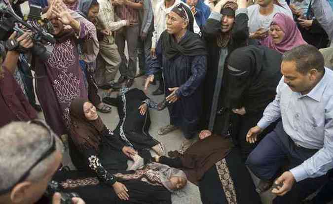 Mulheres desmaiam aps a divulgao de resultado que condenou  morte quase 600 egpcios ligados  Irmandade Muulmana(foto: KHALED DESOUKI/AFP)