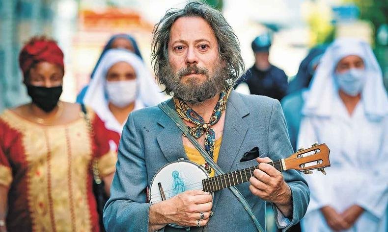 Mathieu Amalric caminha pela rua maltrapilho, como o personagem Tralala