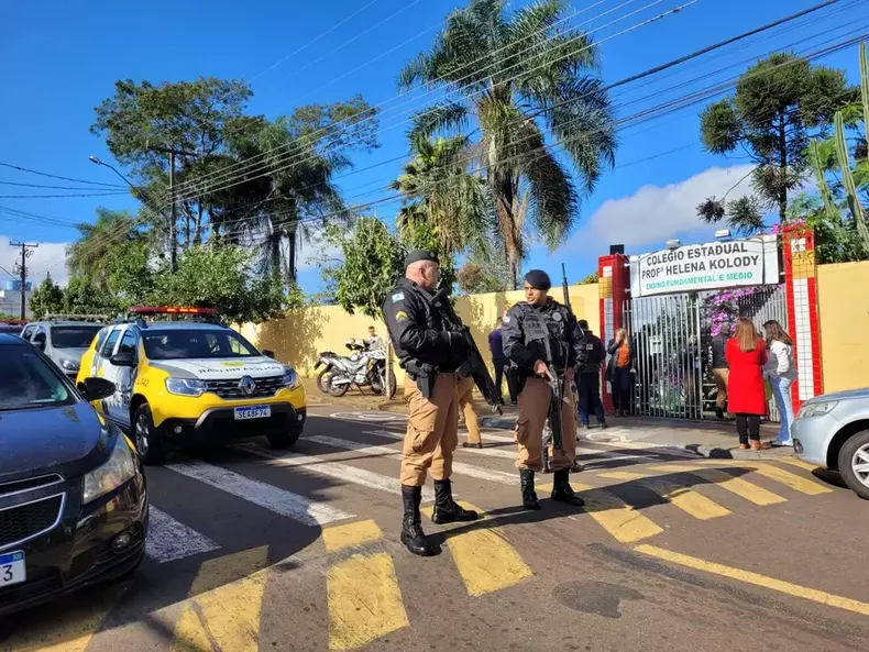 fachada da escola que sofreu atentado, com policiais militares na frente 