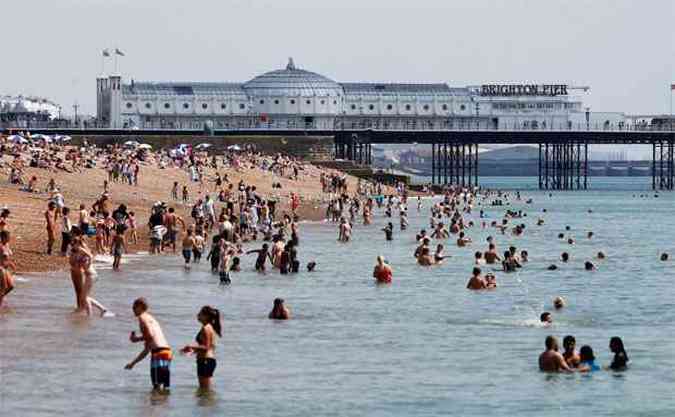 Populao curte o calor e a gua do mar durante o vero na praia de Brighton, na Inglaterra (foto: REUTERS/Luke MacGregor )