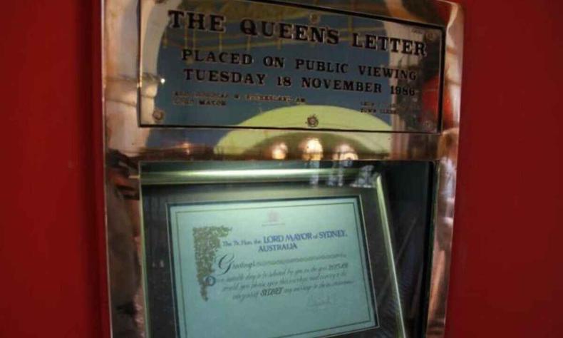 Display dourado com escritos sobre a carta da Rainha Elizabeth II