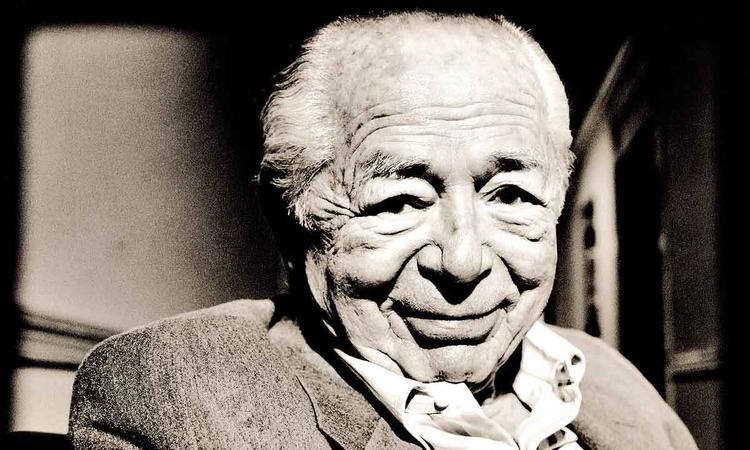 Vestindo camisa e palet, Billy Wilder sorri para a cmera
