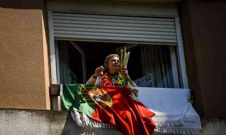 Mulher na janela com sino e bandeira de Portugal