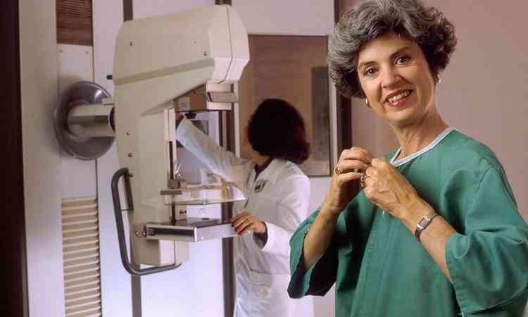 mulher se prepara para fazer o exame mamografia