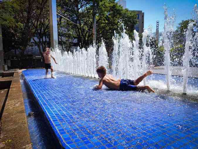 Os irmos Raul, de 5 anos, e seu irmo Benjamin, de 3 anos, moradores do Bairro Cruzeiro, passeando com os pais Larissa e Luis resolveram tomar um banho e se refrescar na fonte da SavassiAlexandre Guzanshe/EM/D.A Press