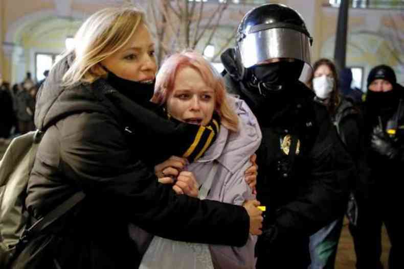 Manifestante chora ao ser levada por policiais russos