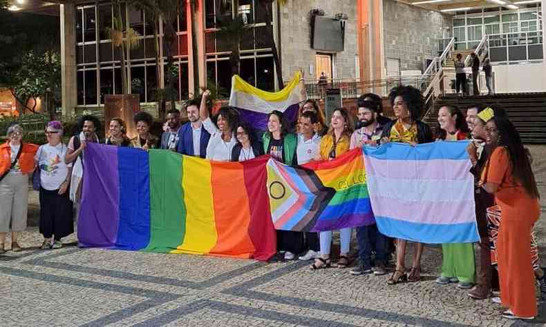 Deputados estaduais reunidos aps audincia pblica contra a LGBTFobia, em maio, na ALMG. H bandeiras das cores do arco-ris e a bandeira trans, que tem as cores azul, rosa e branco