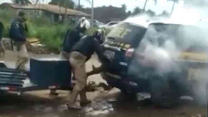Reproduo de imagem de vdeo mostra policiais colocando o homem no porta mala de um carro enfumaado