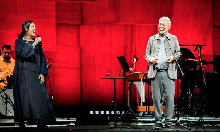 Mnica Salmaso e Chico Buarque cantam em palco com fundo vermelho
