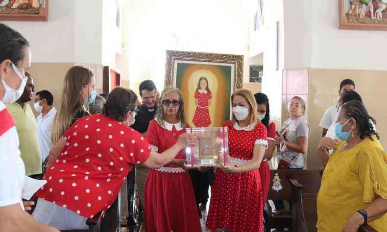 Mulheres vestidas de menina benigna carregando sua imagem na igreja 