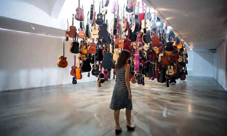 Instalao de violes que pendem do teto da galeria do Viaduto das Artes
