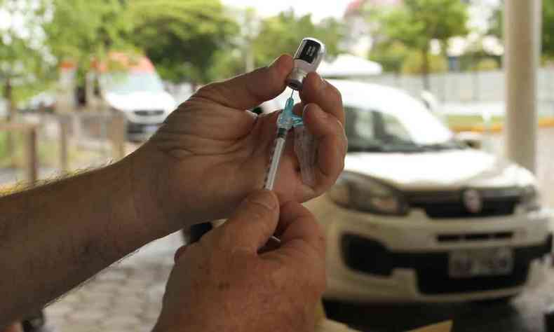 enfermeiro prepara aplicao de vacina contra COVID-19 em sistema drive-thru