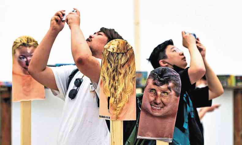 Dois homens fazem selfies na instalao criada por artistas cubanos que rene mscaras de intelectuais que sofrem censura em Cuba 