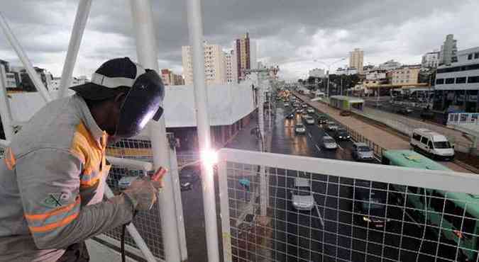 Operrio solda guarda-corpo de uma passarela da Avenida Cristiano Machado, que ainda passa por pintura de faixas de pedestres e muitas outras adaptaes para o BRT/Move(foto: BETO NOVAES/EM/D.A PRESS)