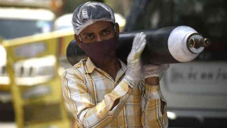 Uma pessoa esperando para reabastecer seu cilindro de oxignio vazio em Gurgaon, ndia; cena aconteceu tanto no Brasil quanto no pais asitico(foto: Getty Images)