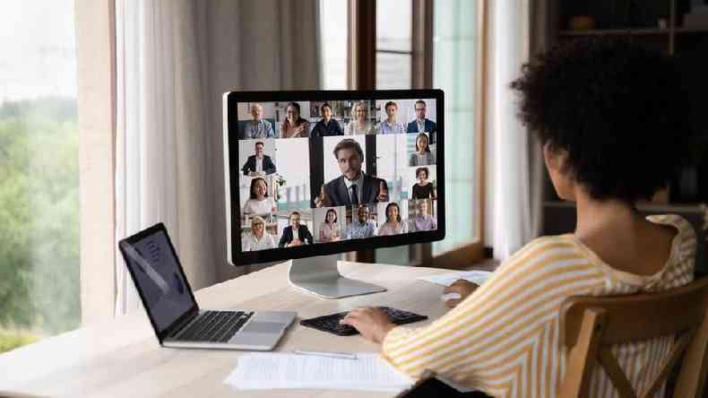 Mulher observa reunio por vdeo na tela de um computador