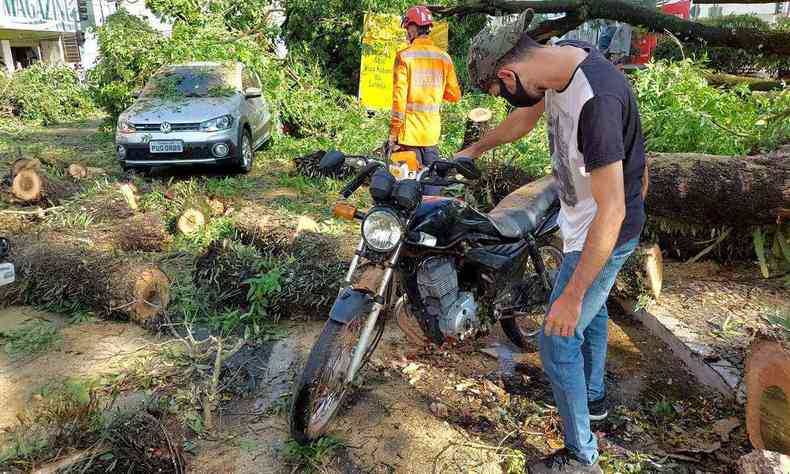 Moto e carro são atingidos por árvore após temporal em Pouso Alegre