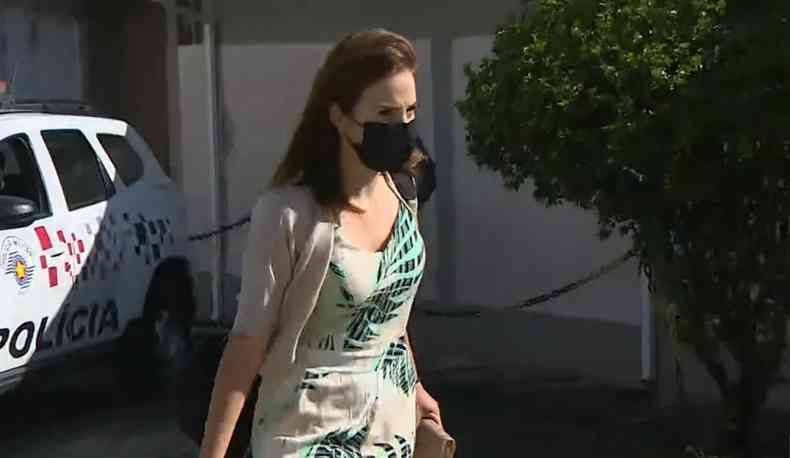 Suzane é uma mulher jovem e está usando máscara de proteção; foto de um a de suas saídas da prisão
